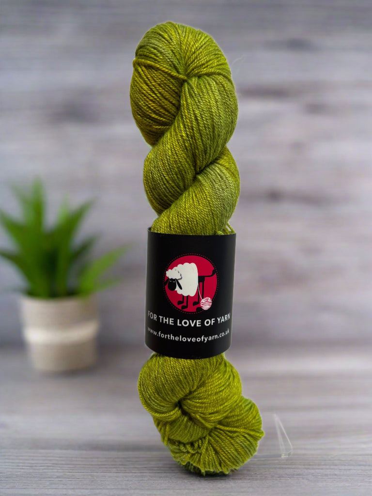 a skein of pure dead brilliant merino silk yak sock in shade of moss green