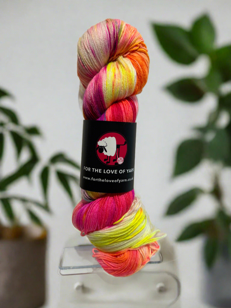A skein of merino and nylon blended yarn in pink, orange and red, Unicorns and Rainbows