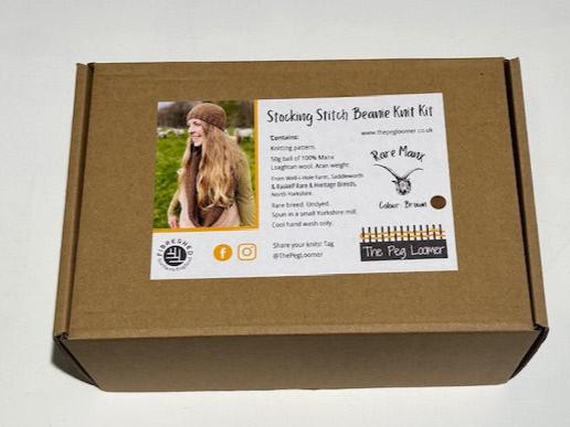 image is of a knitting kit in a box showing and image on the front of a woman wearing a beanie hat